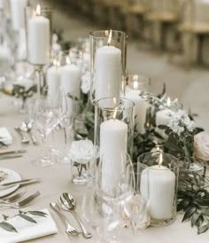 a table topped with lots of white candles