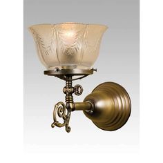 an antique brass wall light with frosted glass shades