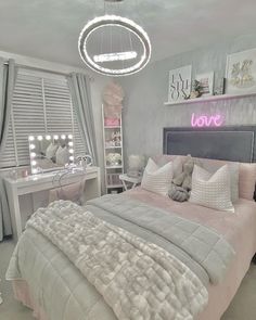 a bed room with a neatly made bed next to a desk and mirror on the wall