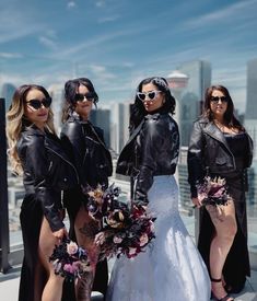 three beautiful women standing next to each other in front of a cityscape with skyscrapers