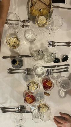 a table topped with lots of glasses and silverware