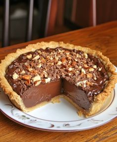 a chocolate pie on a plate with one slice cut out and ready to be eaten