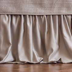 a close up view of a bed skirt with pleated fabric on the top and bottom