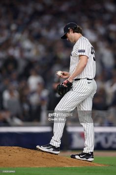 a baseball player standing on top of a mound in the middle of a field with his glove