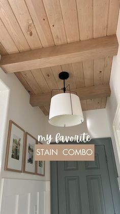 a light fixture hanging from the ceiling in a room with wood paneling and white walls