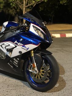 a blue and white motorcycle parked on the street