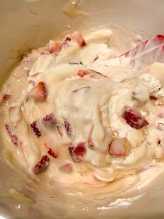 a bowl filled with cream and strawberries in it's batter, ready to be mixed together