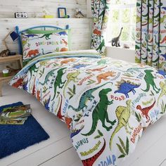 a child's bedroom with dinosaur bedding and curtains