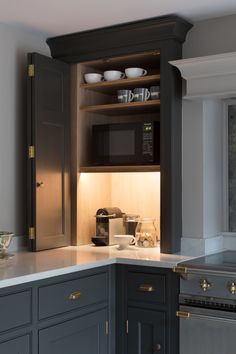 a kitchen with gray cabinets and white counter tops