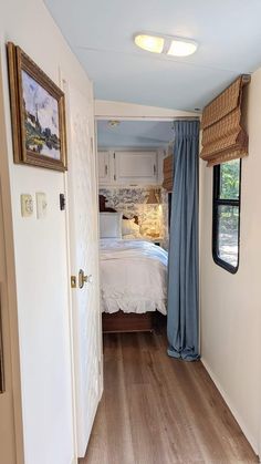 the inside of a mobile home bedroom with a bed and window that opens to another room