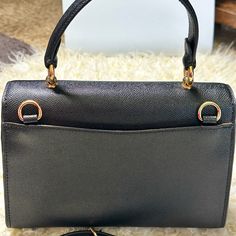 This Beautiful And Rare Coach Tilly Top Handle Satchel Bag Comes In Classy Black Color. It's Crafted From Rich Top Quality Textured Crossgrain Leather And Features A Middle Compartment With Zippered Closure, Gold Tone Signature Hardware, And A Signature Hand Tag. Superior Quality Craftsmanship With A Sleek Silhouette, Attractive Stitching And Many Other Details Gives This Bag A Unique And Classy Look. Top Handle And Long Crossbody/Shoulder Strap Offer Versatile And Comfortable .Nwot High-end Black Flap Bag With Gold-tone Hardware, High-end Black Satchel With Detachable Handle, High-end Black Flap Bag For Travel, High-end Black Satchel With Removable Pouch, High-end Black Top Handle Evening Bag, Business Clutch Bag With Branded Hardware, High-end Black Flap Bag, High-end Black Shoulder Flap Bag, High-end Black Flap Bag With Removable Pouch