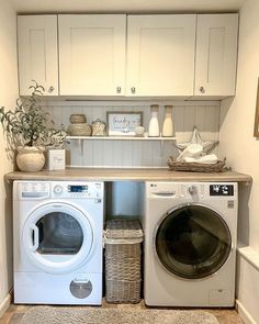 a washer and dryer in a small room with white cabinets on the wall