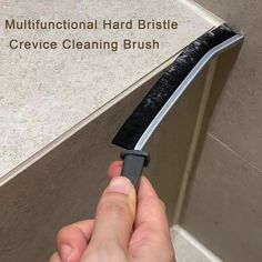 a person holding a brush in their hand with the words, mullifuctional hard bristles crevice cleaning brush