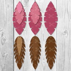 three pink and brown feathers cut out from paper on a white wooden background with the words,