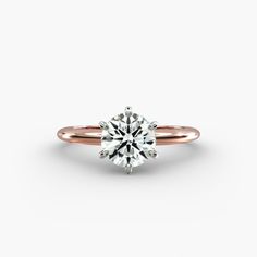 a rose gold engagement ring with a round brilliant cut diamond in the center, on a white background