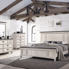 a white bed sitting in a bedroom next to a dresser