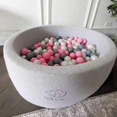 a bowl filled with lots of pink and grey balls