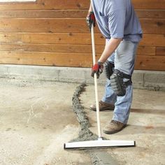 a man using a mop to clean concrete