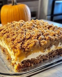 a dessert is sitting on a glass platter with a pumpkin in the back ground