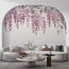 a living room with white furniture and pink flowers on the wall