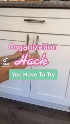 a person holding a door handle in front of a kitchen cabinet with the words organization hack you have to try