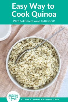 a white bowl filled with quinoa on top of a pink cloth next to a spoon