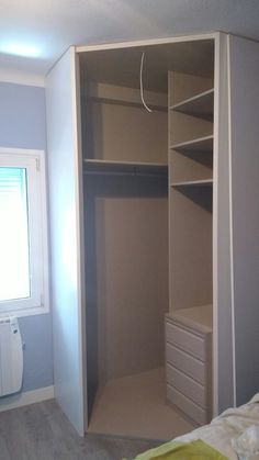 an empty closet in a bedroom with white walls and grey carpeted flooring is shown