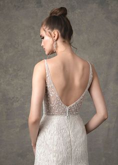 the back of a woman's wedding dress, with an intricate beaded design