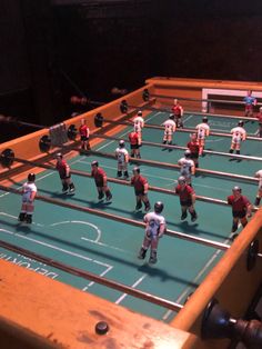 toy football players are lined up on a foo - o - ball table in the dark