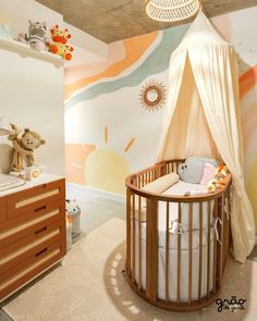 a baby's room with a crib, dressers and wall mural in the background