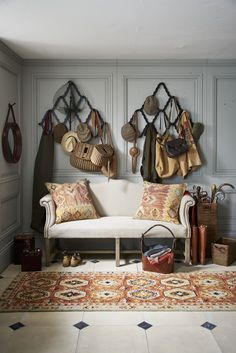 a living room filled with furniture and lots of hats hanging on the wall above it