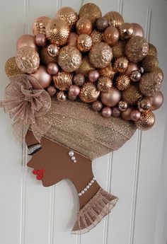 a woman's head made out of ornaments on the front door with her hair in a bun