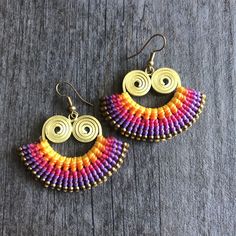 Unique fun multicolor macrame earrings. Made with brass wire, a mix of yellow, orange, violet, fuchsia and magenta brasilian wax cords, and small brass beads. All put together creating this unique fun bright pair that will rock your outfit. Perfect for your day by day outfits. The earrings are 3.2cm- 1.30 inch long 5cm- 2 inch wide Drop length of 4.6cm- 1.90 inch They are super light what makes them easy to wear. A unique addition to your jewelry collection Enjoy Con salud Multicolor Macrame Earrings As Gift, Multicolor Woven Drop Earrings, Adjustable Rainbow Earrings For Beach, Brasilian Wax, Multicolor Macrame, Magenta Earrings, Violet Earrings, Earrings Macrame, Wiccan Necklace