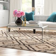 a living room filled with furniture and flowers on top of a coffee table in front of a window