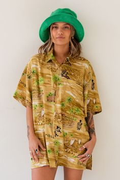 Vintage x Resurrection Hawaiiana Oversized Button Shirt features a retro Hawaiian design with button down front and chest pocket. Color: Gold/Green Multi Oversized Fit Short Sleeve Silk Brand: Creations Mens Size Large There will be imperfections and flaws that make this jacket unique in character with no two alike. There are some minor tears. These are not defects and simply lend to the character of this extra special piece. VINTAGE - FINAL SALE ITEM Retro Collared Hawaiian Shirt With Relaxed Fit, Retro Hawaiian Shirt With Relaxed Fit, Retro Hawaiian Shirt For Beach With Button Closure, Retro Hawaiian Shirt For The Beach, Retro Relaxed Fit Collared Hawaiian Shirt, Vintage Long Sleeve Hawaiian Shirt For Vacation, Vintage Relaxed Fit Shirt For Vacation, Vintage Hawaiian Shirt For Spring With Button Closure, Retro Vacation Tops With Button Closure