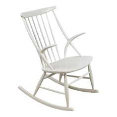 a white rocking chair on a white background with no one in it's seat