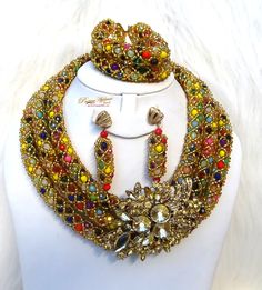 New Design Gold multi-colour African Nigerian Beads Party Bridal Wedding Set Complete Set is Necklace Earring and bracelet. The brooch might a different design as pictured but it will be similar. We will use accessories that are in vogue at the time of production.  Wedding Party Bridal Special Occasion This detailed Jewellery set makes you stand out elegantly in any special occasion, it's all about glamour and uniqueness.  Buying more than 1 Jewellery set, we offer wholesale and bulk prices for Multicolor Costume Jewelry Sets For Weddings, Multicolor Gold Beaded Jewelry For Wedding, Multicolor Costume Jewelry Beads For Party, Multicolor Gold Beads Jewelry For Celebration, Multicolor Beads For Party Costume Jewelry, Multicolor Beads For Costume Jewelry Party, Unique Multicolor Jewelry With Gold Beads, Unique Multicolor Party Jewelry, Multicolor Beaded Crystal Jewelry