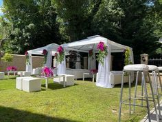 an outdoor wedding setup with white chairs and pink flowers