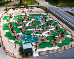 an aerial view of a miniature golf course in the middle of a parking lot with cars parked nearby