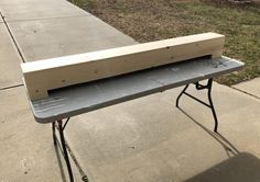 a wooden bench sitting on top of a sidewalk