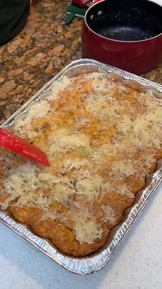 an uncooked casserole dish on a counter with a red spatula