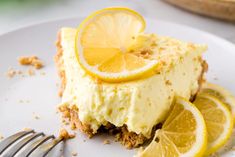 a slice of lemon pie on a plate with a fork next to the rest of the pie