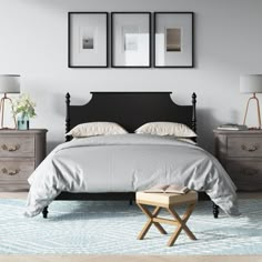 a bedroom with three framed pictures on the wall above the bed and two nightstands