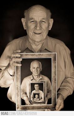 an old man holding up a framed photo with the image of himself in black and white