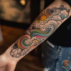 a person with a tattoo on their arm holding up a colorful wave and sun in the sky