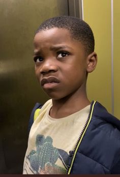 a young boy standing in front of an elevator