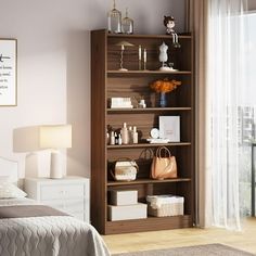 a bed room with a neatly made bed and a book shelf next to a window