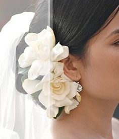 a woman wearing a veil and flowers in her hair