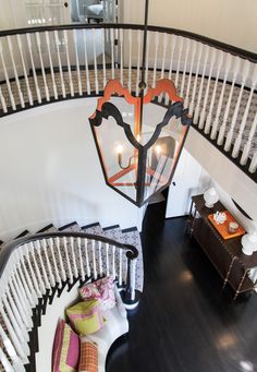 an overhead view of a spiral staircase and chandelier in a home with white railings