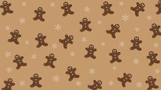 a group of gingerbread men standing next to each other on a brown background with snowflakes